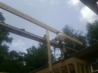 Carpenter setting a ridge beam over a new addition frame — Ice Dam Removal by Roofing Brothers in Center Tuftonboro