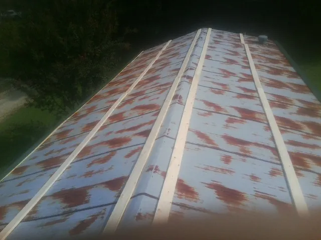 Rusted metal roof panels with new wood purlins before replacement — Storm Damage Roof Repair in Center Tuftonboro by Roofing Brothers