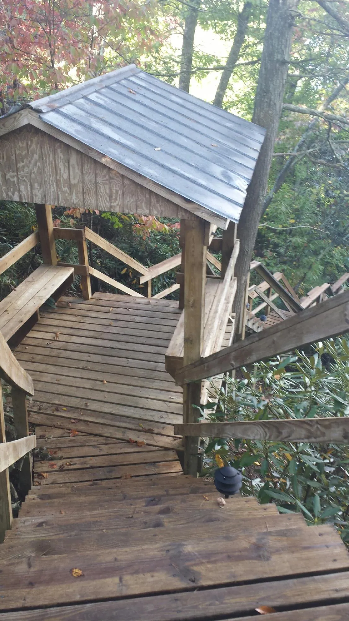 Metal roofed shelter over wooden steps on a wooded walkway — Skylight Repair & Installation work by our crew in Center Tuftonboro
