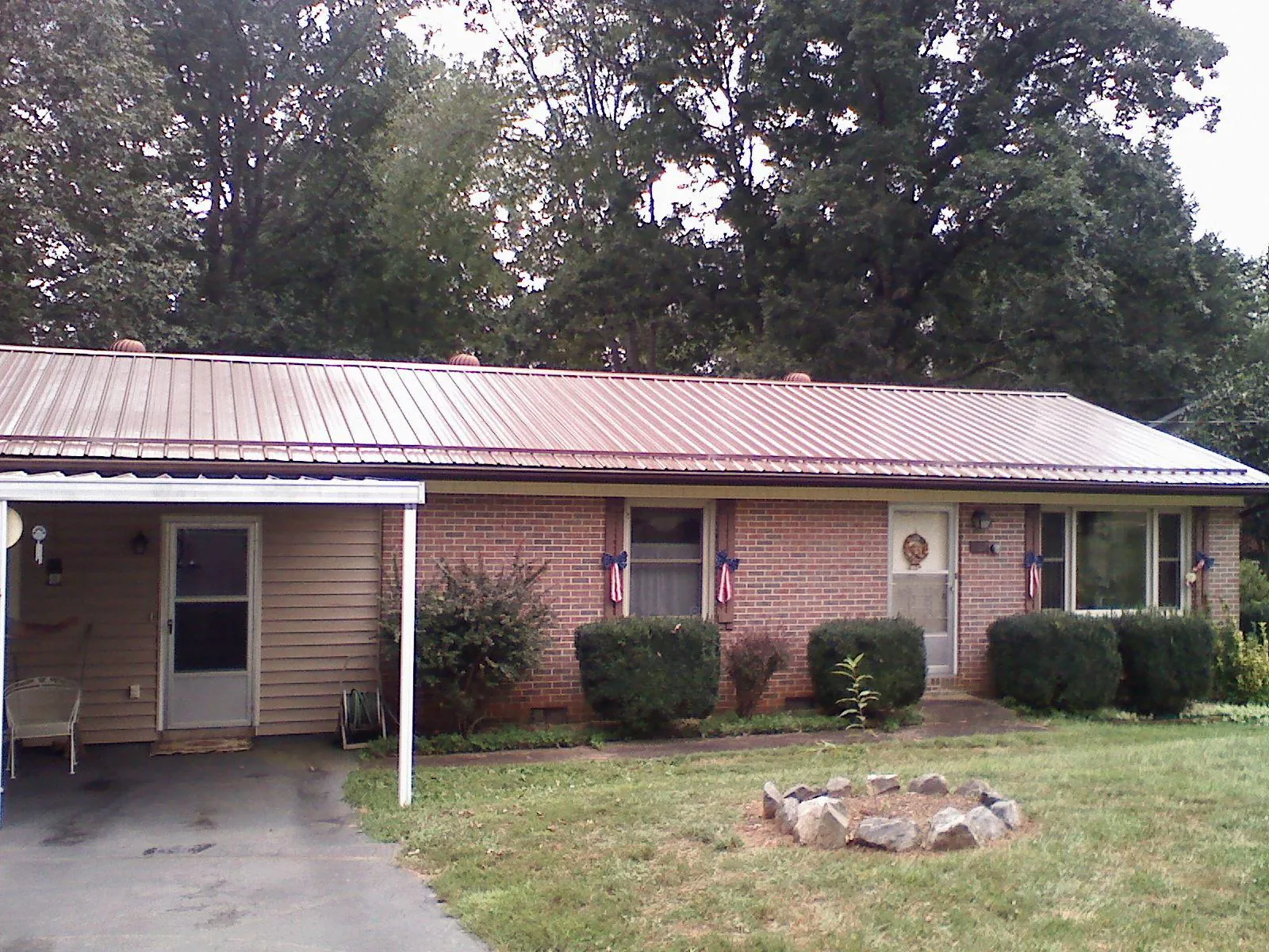 Bronze metal roof and carport on a brick ranch home — Roof Repair work by our crew in Center Tuftonboro